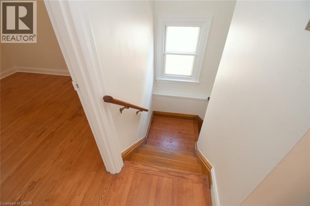 Stairway with baseboards and wood finished floors - 136 Glen Road, Hamilton, ON - Indoor Photo Showing Other Room
