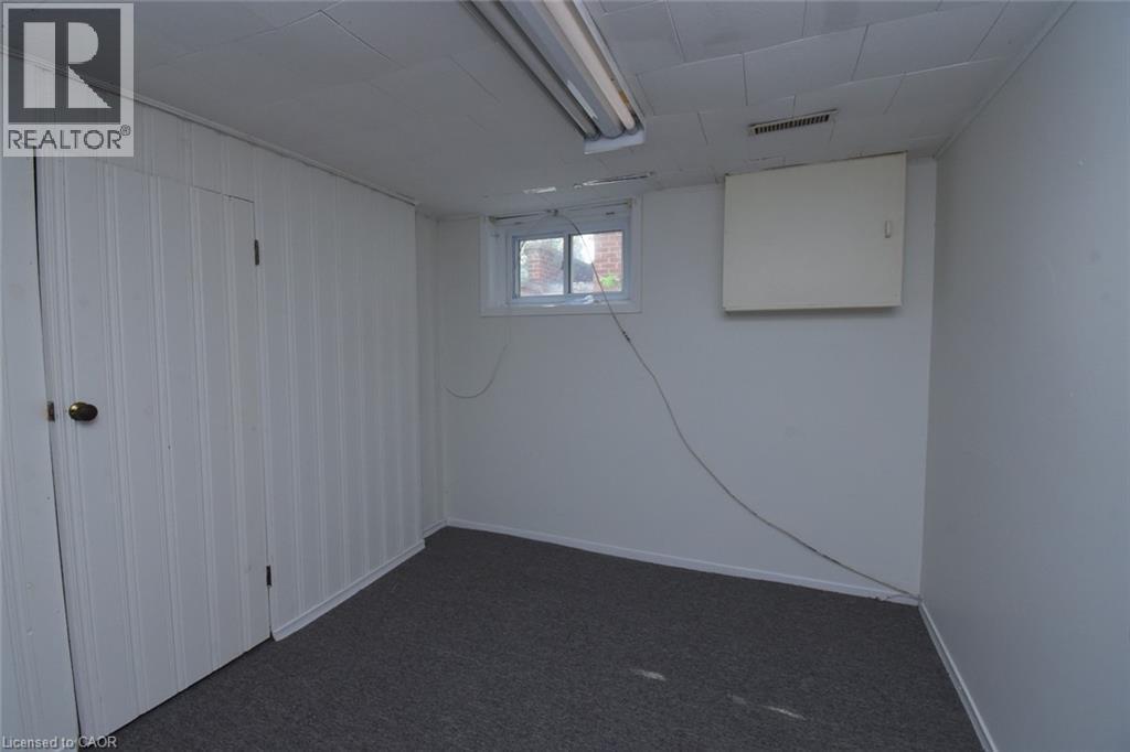 Below grade area with dark colored carpet and baseboards - 136 Glen Road, Hamilton, ON - Indoor Photo Showing Other Room