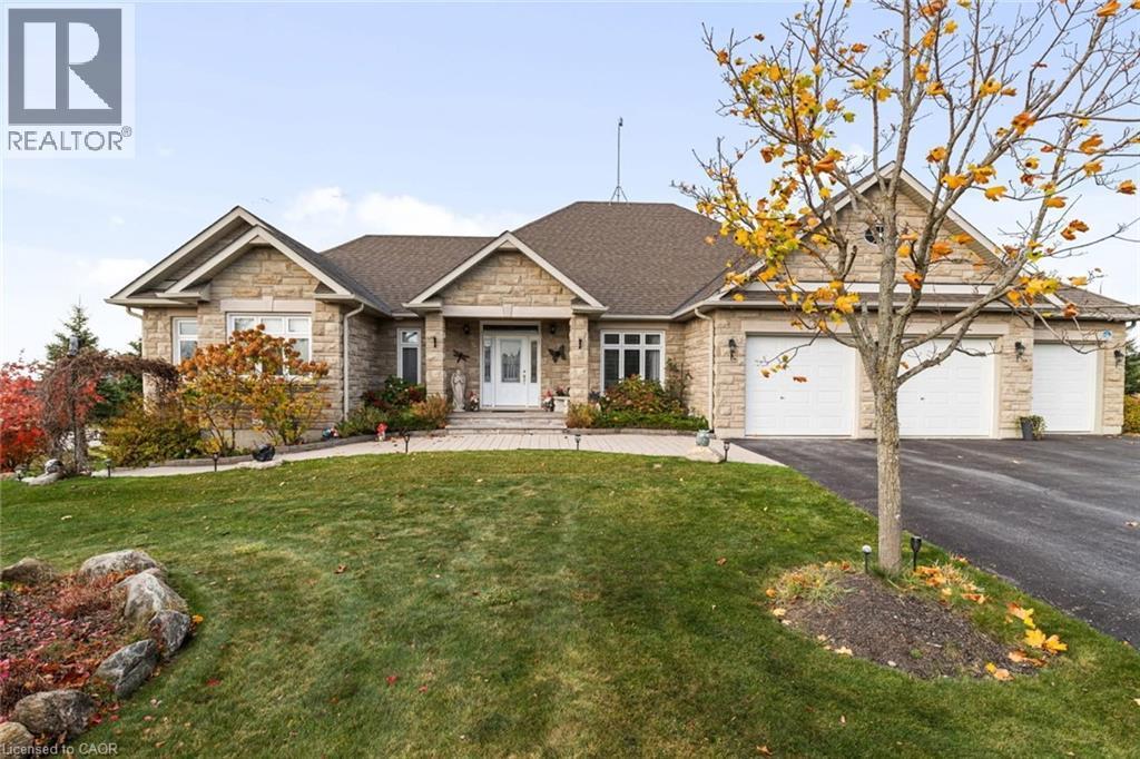 Craftsman-style house with stone exterior, triple wide driveway, manicured yard, and an oversized 3 car garage - 10 Brolley Crescent, Thornton, ON - Outdoor With Facade
