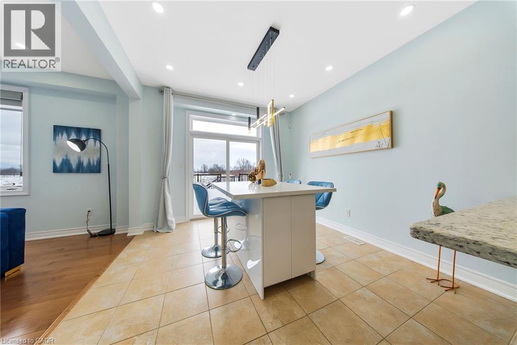 Kitchen with a kitchen breakfast bar, decorative light fixtures, light tile patterned floors, and a center island - 59 Greti Drive, Hamilton, ON - Indoor