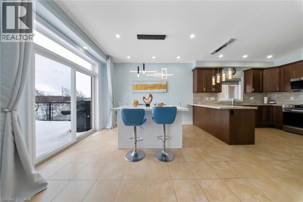 Kitchen with a breakfast bar, decorative light fixtures, tasteful backsplash, and stainless steel appliances - 59 Greti Drive, Hamilton, ON - Indoor Photo Showing Kitchen