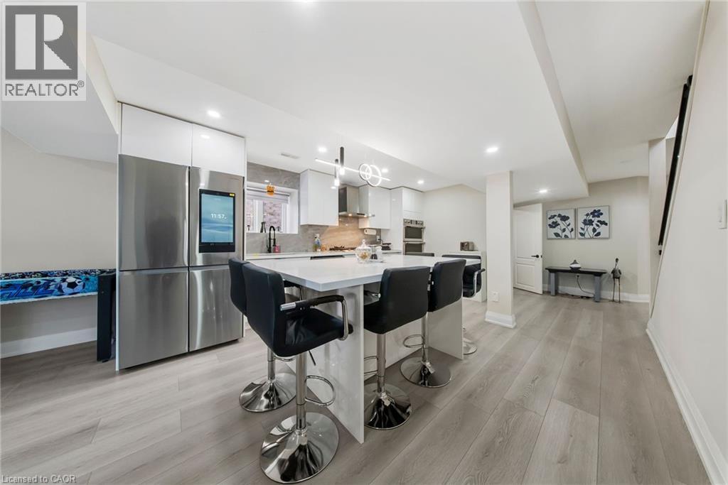 Kitchen with white cabinetry, smart refrigerator, modern cabinets, light wood finished floors, and a center island - 59 Greti Drive, Hamilton, ON - Indoor Photo Showing Kitchen With Upgraded Kitchen