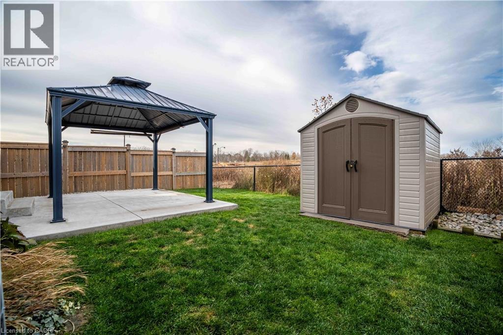 Fenced private backyard featuring a storage shed, a gazebo, and poured concrete patio - 115 Larry Crescent, Caledonia, ON - Outdoor