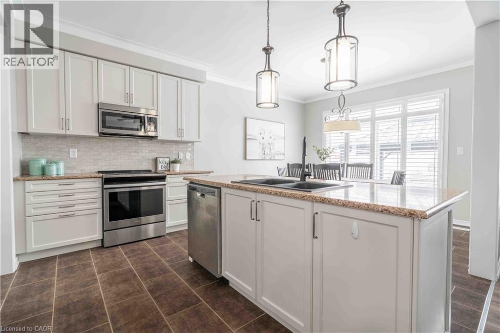 Alternate view of kitchen showing ample cabinetry, crown molding and easy access to living spaces beyond. - 115 Larry Crescent, Caledonia, ON - Indoor Photo Showing Kitchen With Double Sink With Upgraded Kitchen