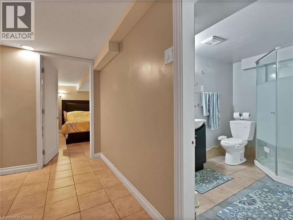 Ensuite bathroom with light tile patterned flooring, vanity, and a stall shower - 210 East 24Th Street, Hamilton, ON - Indoor Photo Showing Bathroom