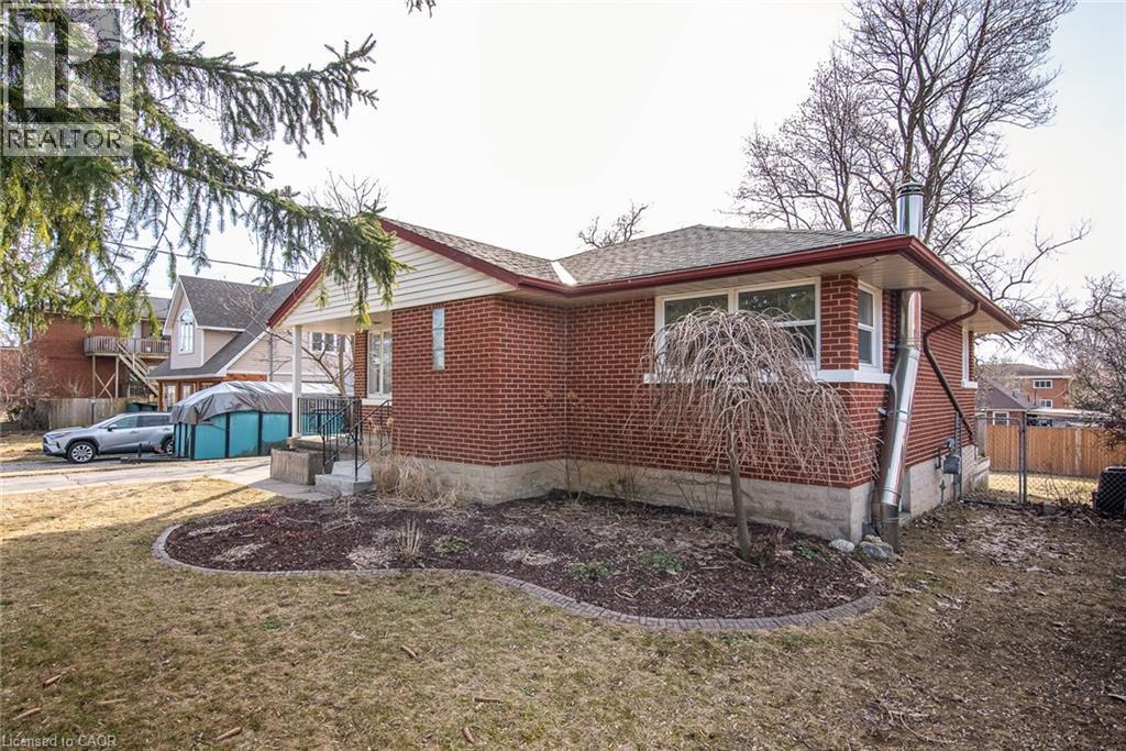 View of side of home with brick siding and a shingled roof - 120 Fourth Avenue, Kitchener, ON