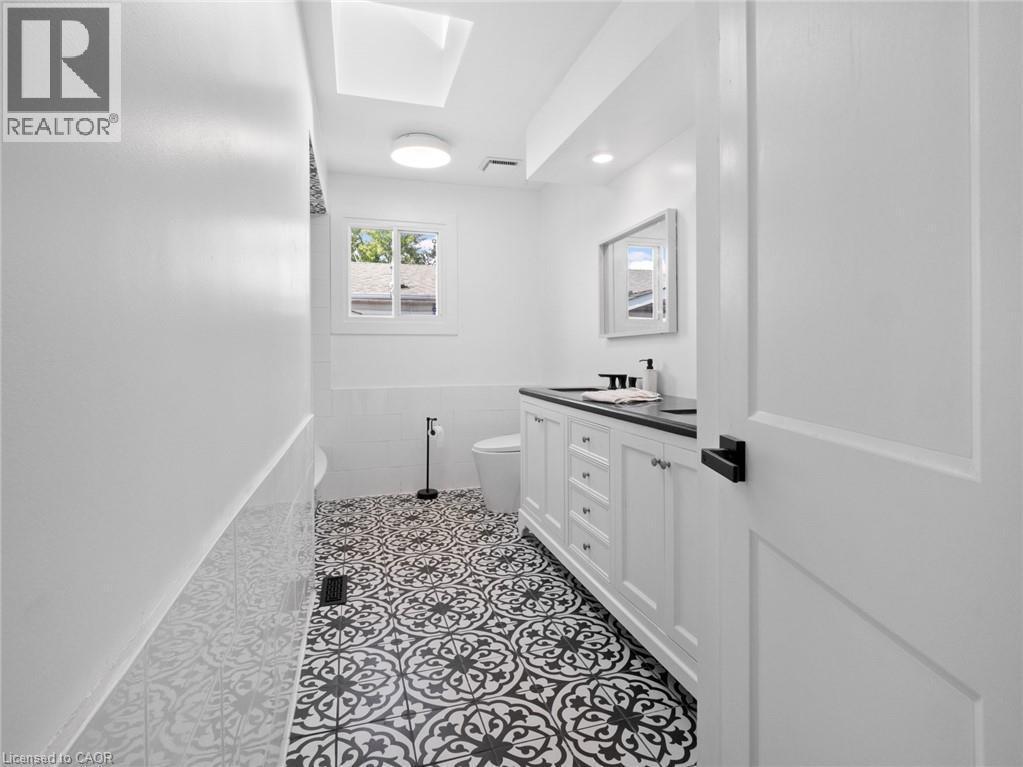 Bathroom featuring tile walls, visible vents, toilet, vanity, and tile patterned flooring - 24 Keefer Road, Thorold, ON - Indoor