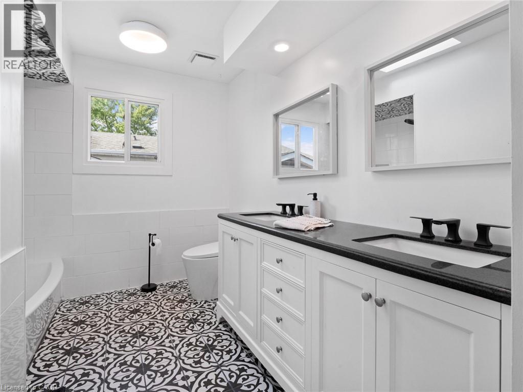 Bathroom featuring visible vents, a sink, toilet, and double vanity - 24 Keefer Road, Thorold, ON - Indoor Photo Showing Bathroom