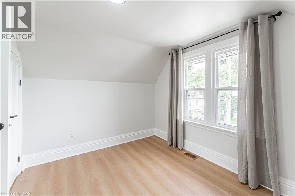 Bedroom with closet, hardwood & bright window. - 15 Barnesdale Avenue N, Hamilton, ON - Indoor Photo Showing Other Room