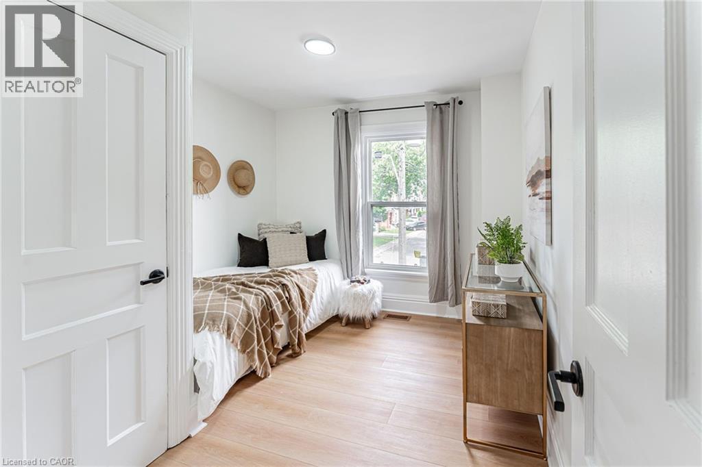 Spacious bedroom with closet & window for natural light. - 15 Barnesdale Avenue N, Hamilton, ON - Indoor Photo Showing Bedroom