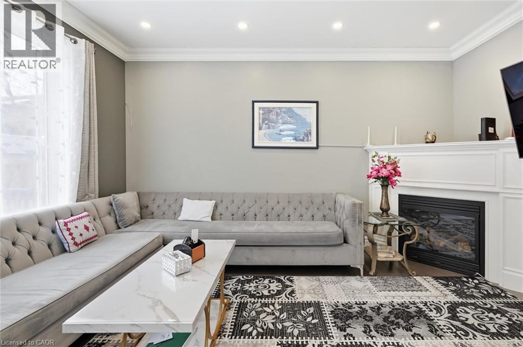 Living area with crown molding, plenty of natural light, a glass covered fireplace, and recessed lighting - 456 Valridge Drive, Ancaster, ON - Indoor Photo Showing Living Room With Fireplace