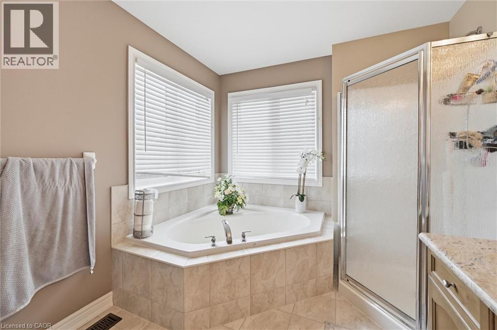Full bath featuring a stall shower, a bath, vanity, and light tile patterned floors - 456 Valridge Drive, Ancaster, ON - Indoor Photo Showing Bathroom