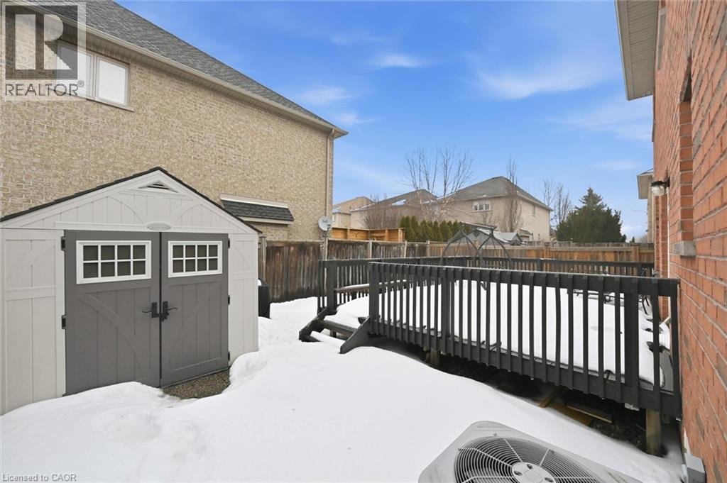 Yard layered in snow featuring a storage unit, a wooden deck, and a fenced backyard - 456 Valridge Drive, Ancaster, ON - Outdoor With Exterior