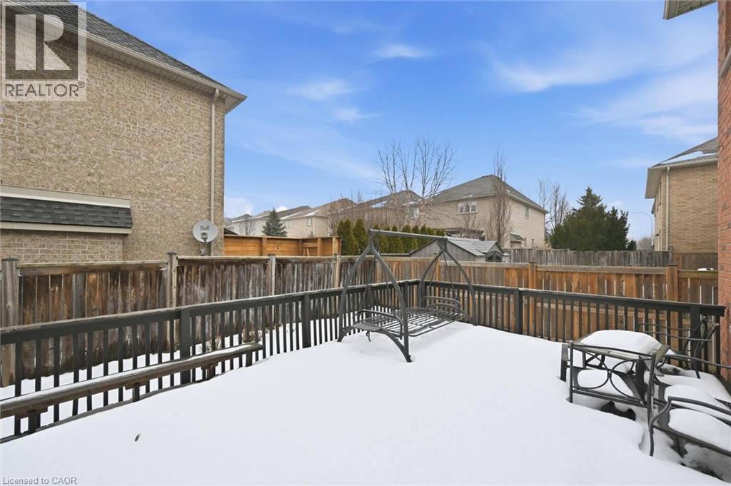Snowy yard with a fenced backyard, a deck, and a residential view - 456 Valridge Drive, Ancaster, ON - Outdoor With Exterior
