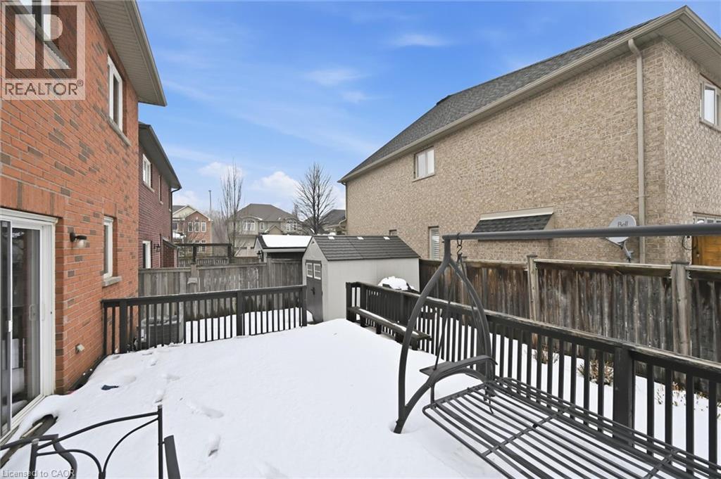 Snow covered deck featuring a shed, a fenced backyard, and a residential view - 456 Valridge Drive, Ancaster, ON - Outdoor With Exterior
