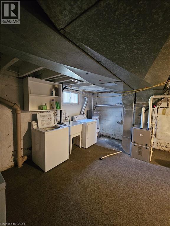 Below grade area featuring heating unit, washer and clothes dryer, and water heater - 59 Dunkirk Drive, Hamilton, ON - Indoor Photo Showing Laundry Room