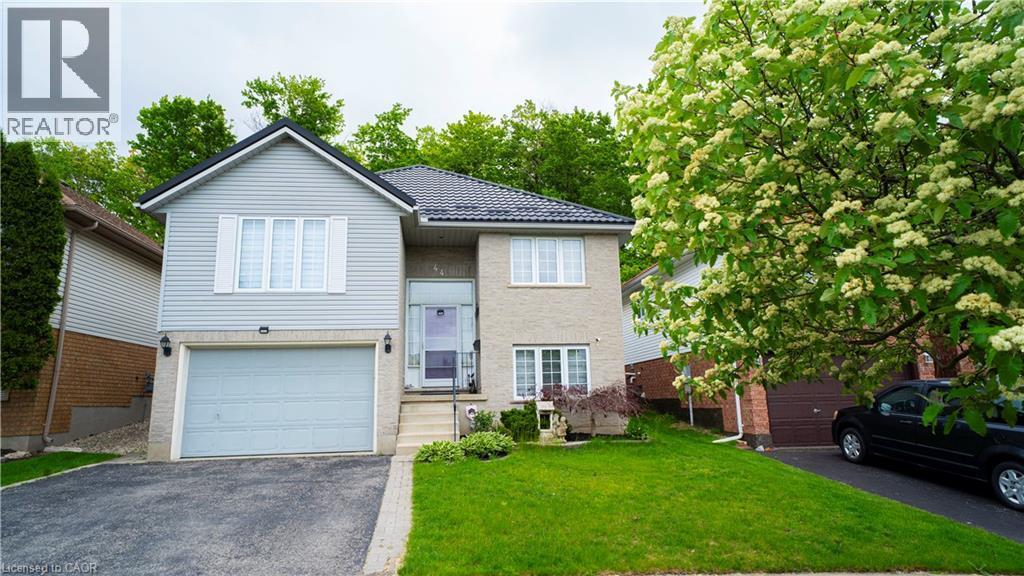 Bi-level home with an attached garage, asphalt driveway, a front lawn, and a tile roof - 44 Dunnigan Drive E, Kitchener, ON - Outdoor