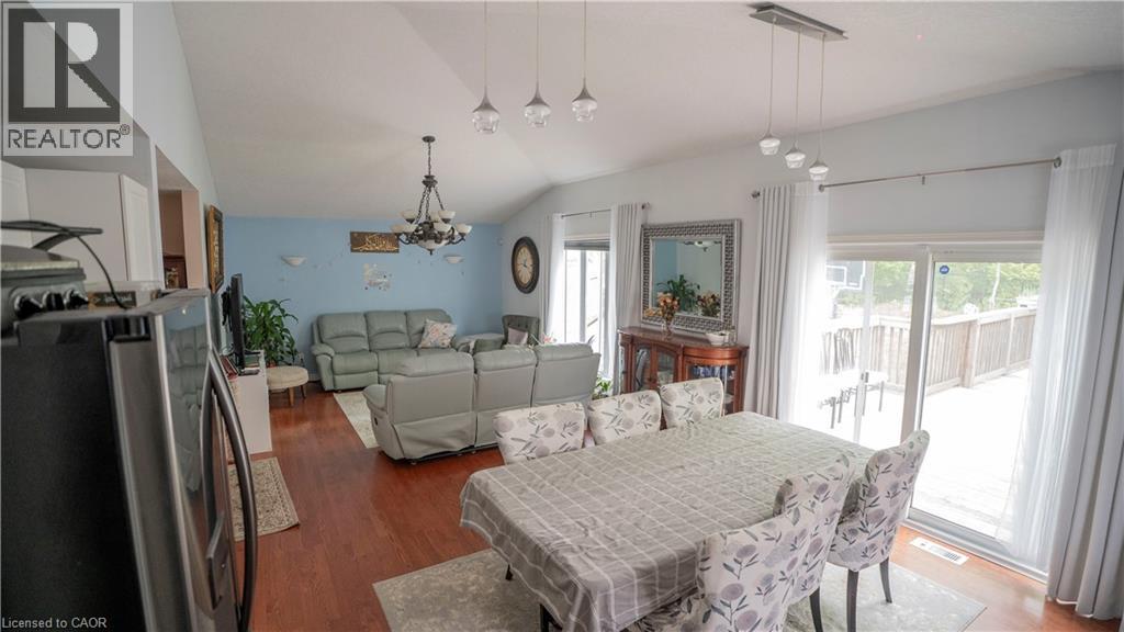 Dining space featuring a chandelier, dark wood-style floors, and vaulted ceiling - 44 Dunnigan Drive E, Kitchener, ON - Indoor Photo Showing Dining Room