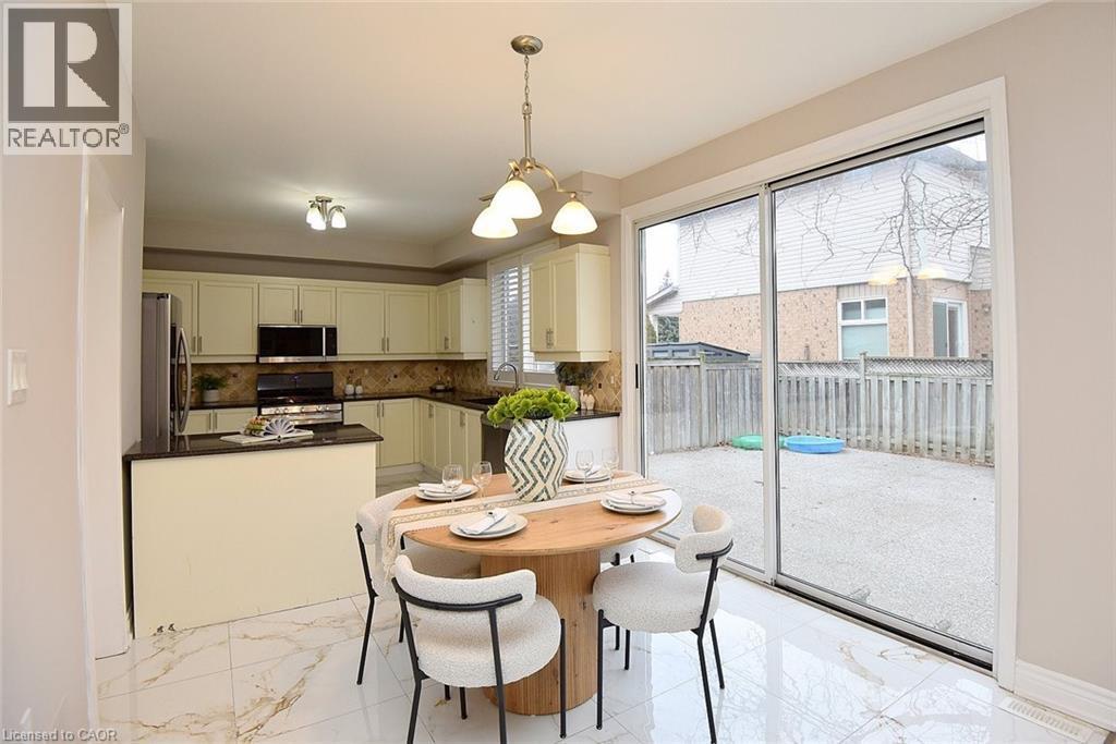 Dining area featuring suspended lighting and light marble finish floors - 5109 Blue Spruce Avenue, Burlington, ON - Indoor Photo Showing Dining Room
