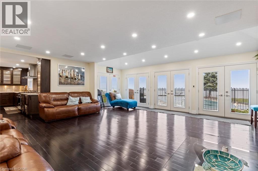Living room with french doors and dark wood-type flooring - 1073 North Service Road, Hamilton, ON - Indoor