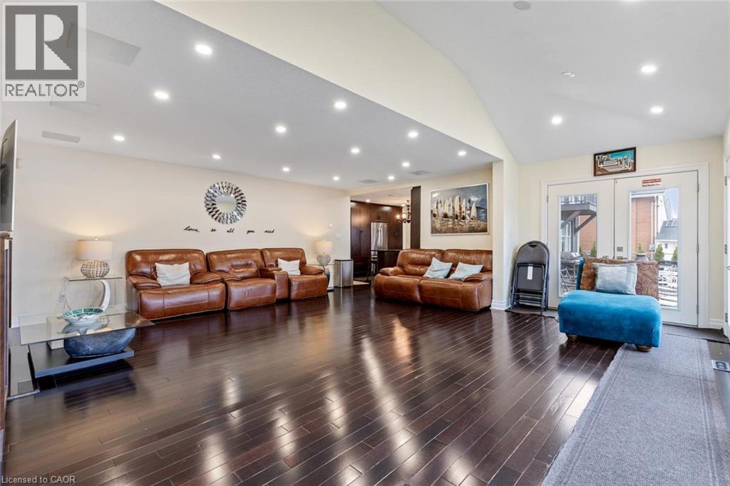 Living room with dark hardwood / wood-style flooring, high vaulted ceiling, and french doors - 1073 North Service Road, Hamilton, ON - Indoor Photo Showing Living Room