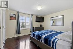 Bedroom with a textured ceiling and dark hardwood / wood-style floors -