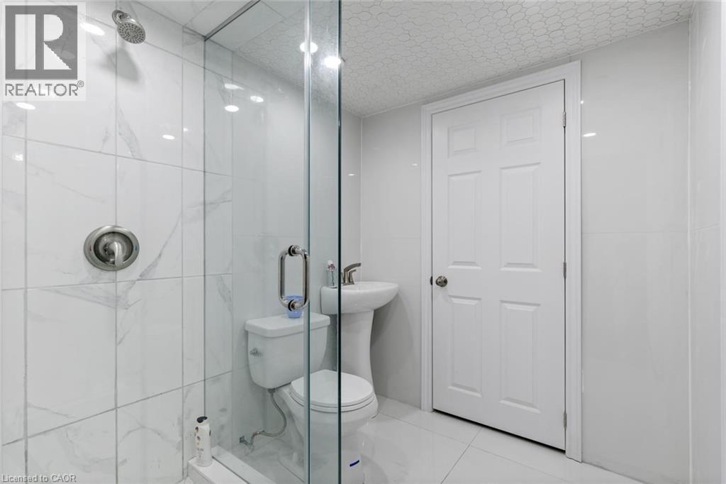Bathroom featuring tile patterned floors, a shower with shower door, and toilet - 1073 North Service Road, Hamilton, ON - Indoor Photo Showing Bathroom