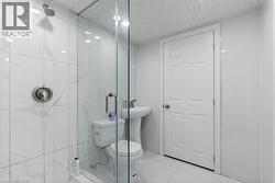 Bathroom featuring tile patterned floors, a shower with shower door, and toilet -