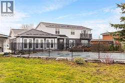 Back of property featuring a yard and a covered pool -