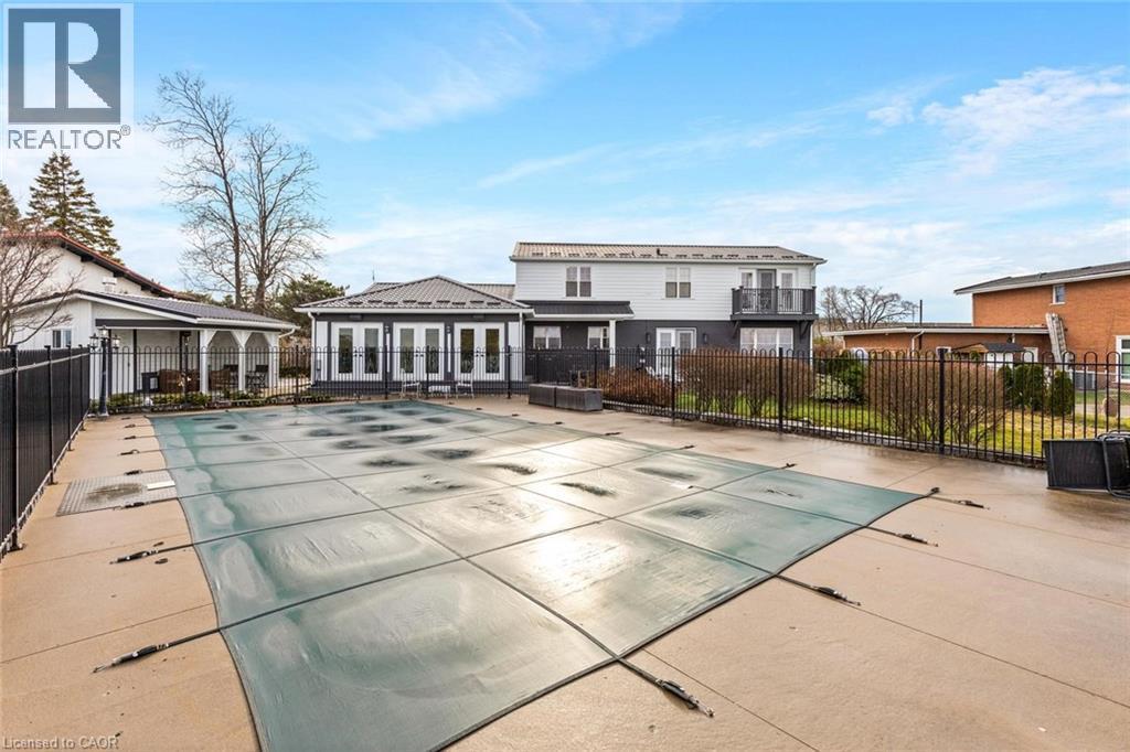 Rear view of house with a patio and a covered pool - 1073 North Service Road, Hamilton, ON - Outdoor