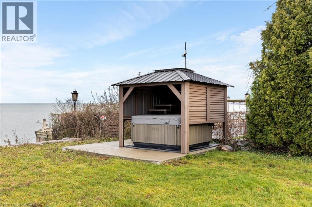 View of outbuilding featuring a yard, a water view, and a hot tub - 1073 North Service Road, Hamilton, ON - Outdoor