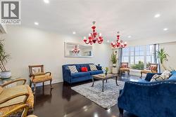 Living room featuring ornamental molding, dark wood-type flooring, and an inviting chandelier -