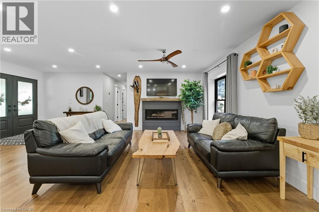 Living room featuring hardwood / wood-style flooring, a fireplace, french doors, recessed lighting, and ceiling fan - 115 Lakeshore Road, Port Burwell, ON - Indoor Photo Showing Living Room With Fireplace