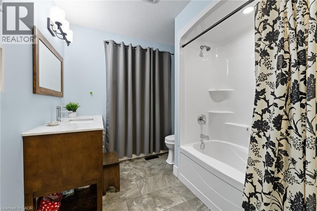 Bathroom with shower / tub combo with curtain, vanity, and a textured ceiling - 115 Lakeshore Road, Port Burwell, ON - Indoor Photo Showing Bathroom