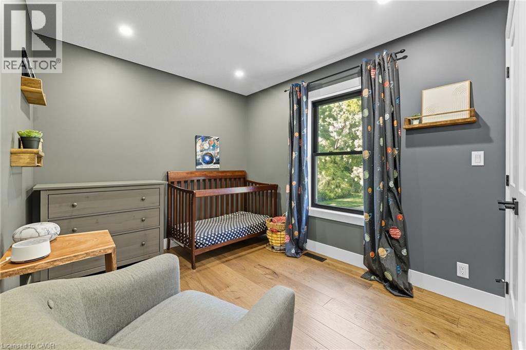Bedroom with light wood-style flooring, a crib, and recessed lighting - 115 Lakeshore Road, Port Burwell, ON - Indoor