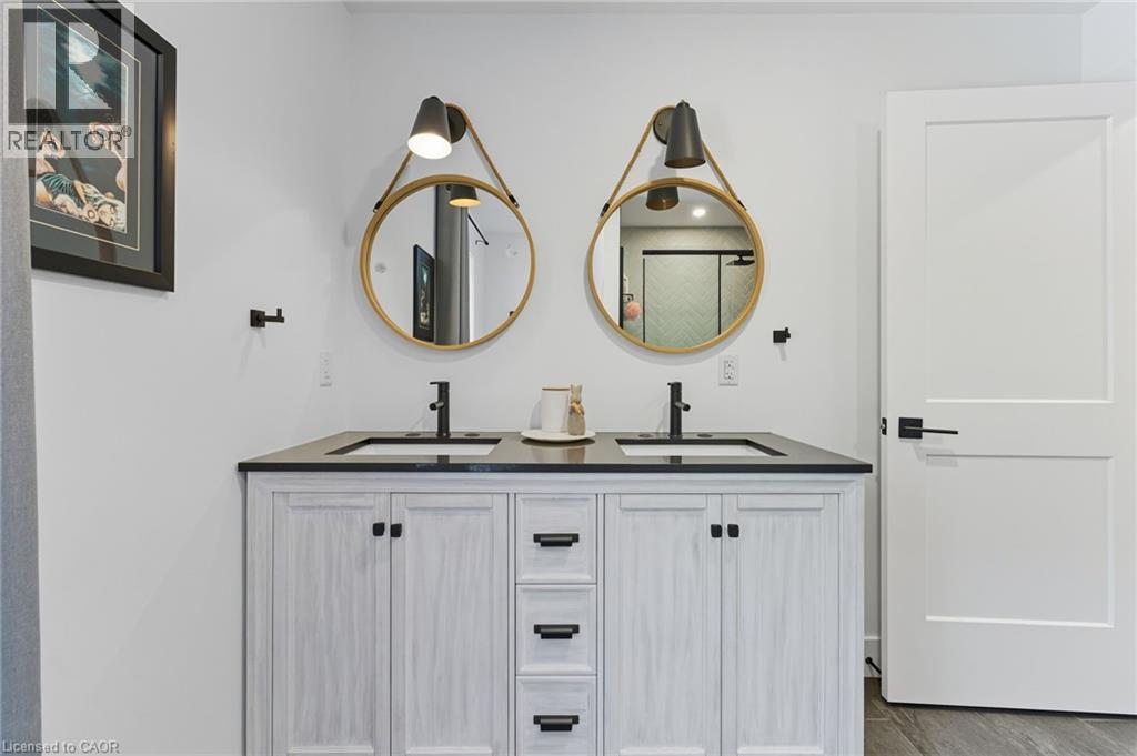 Full bath with double vanity, a shower stall, and wood finished floors - 115 Lakeshore Road, Port Burwell, ON - Indoor