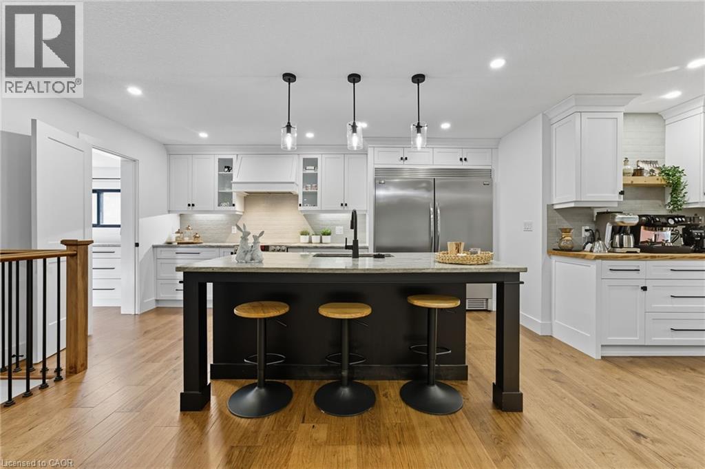 Kitchen with white cabinetry, a breakfast bar area, pendant lighting, an island with sink, and recessed lighting - 115 Lakeshore Road, Port Burwell, ON - Indoor Photo Showing Kitchen With Upgraded Kitchen