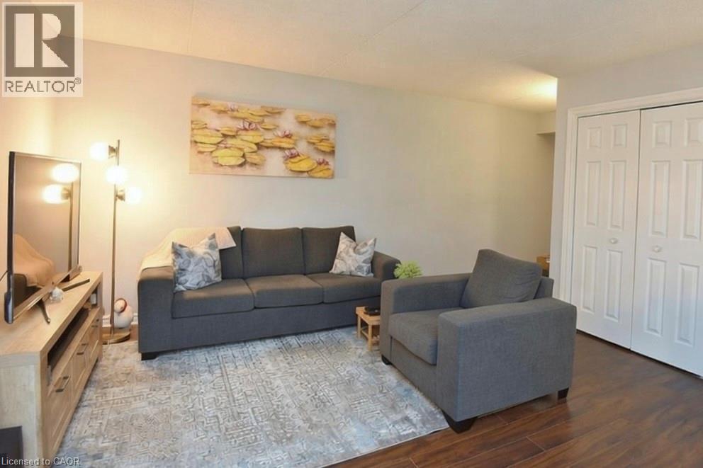 Comfortable living space with durable and stylish vinyl flooring - 1411 Walkers Line Unit# 202, Burlington, ON - Indoor Photo Showing Living Room