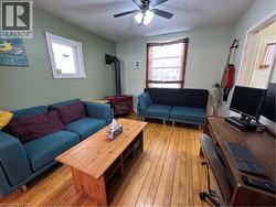comfortable living room, warmed by a red gas stove and ceiling fan -