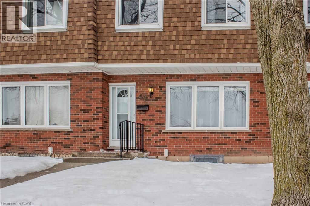 Snow covered property entrance with brick siding and a shingled roof - 48 Riverdale Drive Unit# 2, Hamilton, ON - Outdoor With Exterior