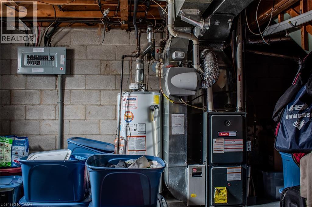 Utility room featuring water heater, electric panel, heating unit, and laundry. - 48 Riverdale Drive Unit# 2, Hamilton, ON - Indoor Photo Showing Basement