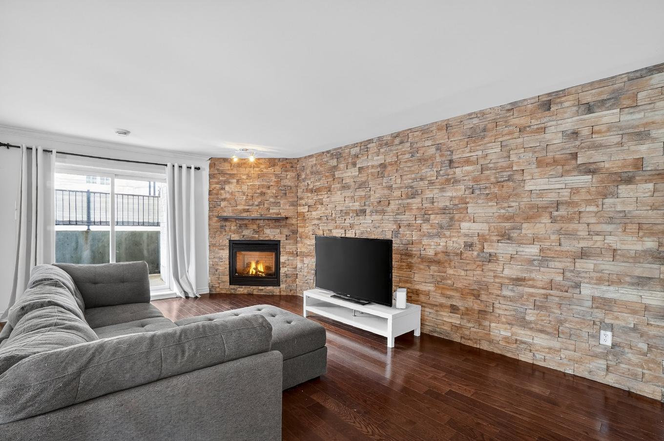 Living room - 101-2365 Rue Versailles, Mascouche, QC - Indoor Photo Showing Living Room With Fireplace