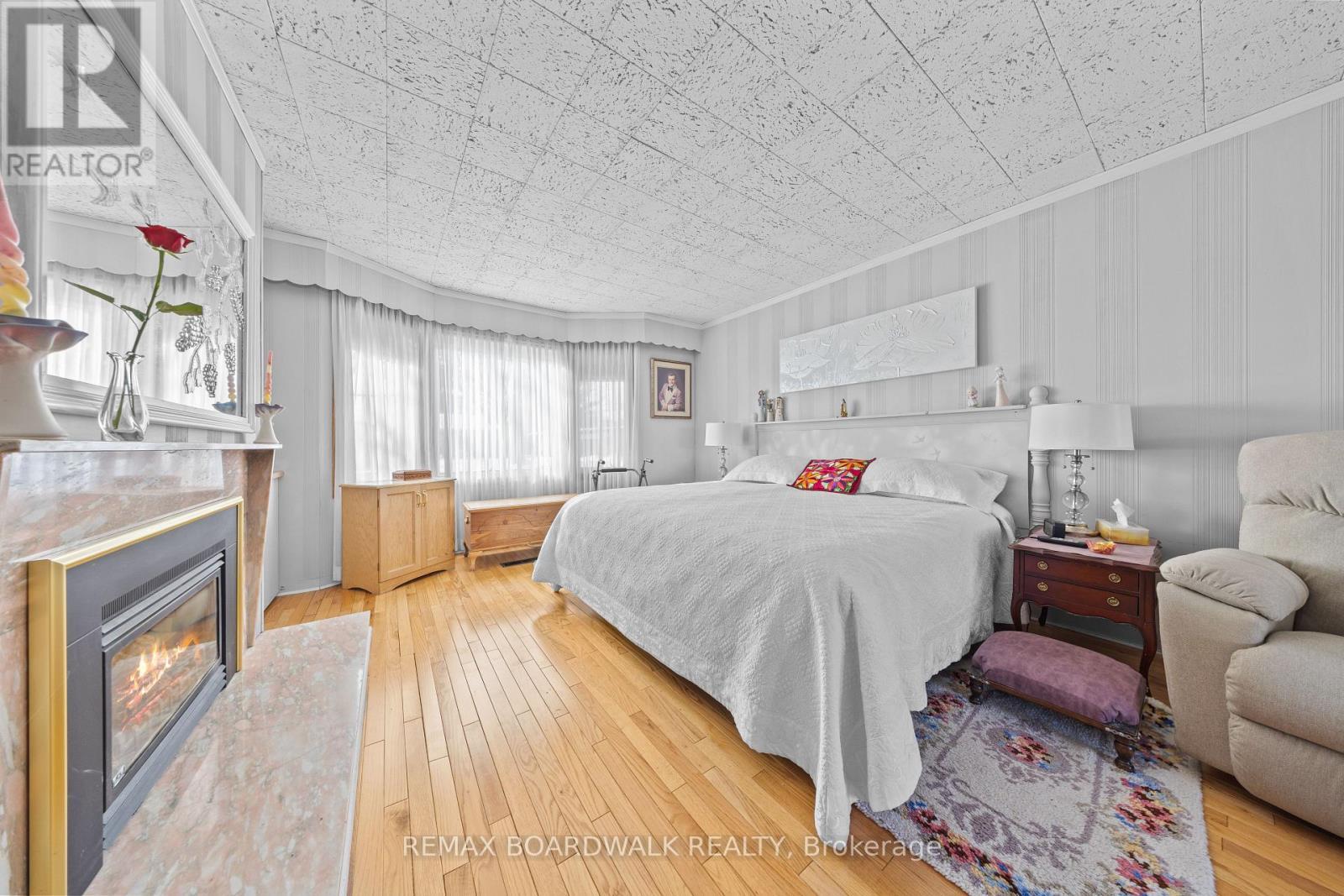 Main Level Primary Bedroom - 961 Kingsmere Avenue, Ottawa, ON - Indoor Photo Showing Bedroom With Fireplace