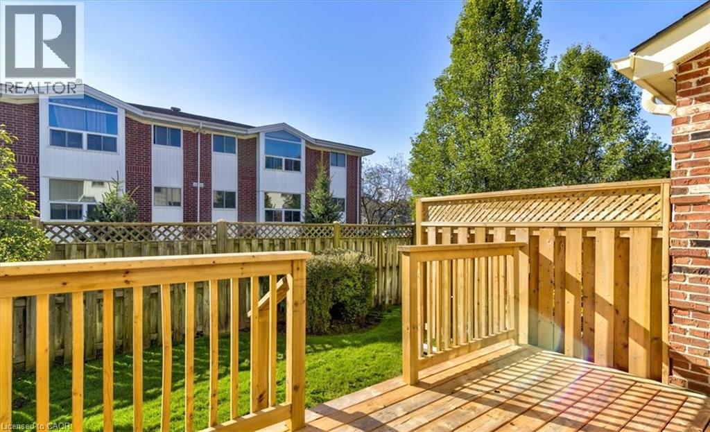 Your private backyard deck offers space for relaxing, while the small yard is perfect for easy upkeep. - 42 Donly Drive S Unit# 2, Simcoe, ON - Outdoor With Deck Patio Veranda With Exterior