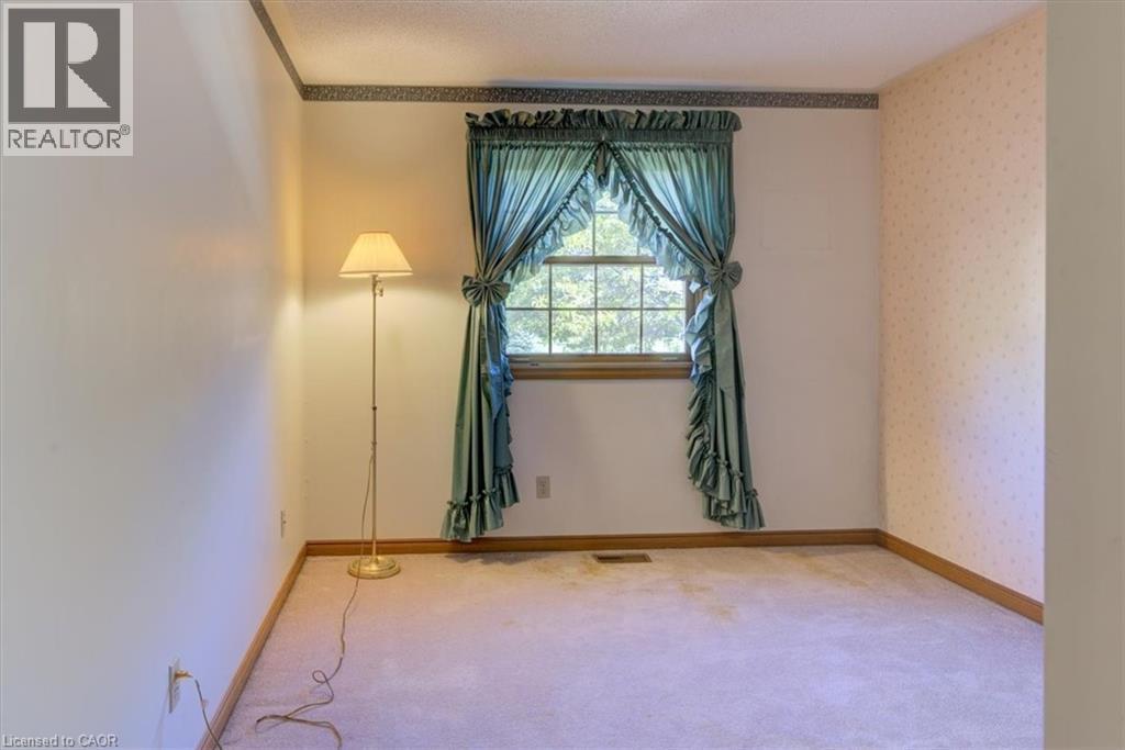 Upper North-East Bedroom 2: This cozy bedroom features soft carpet and charming wood trim, perfect for relaxation and quiet mornings. - 42 Donly Drive S Unit# 2, Simcoe, ON - Indoor Photo Showing Other Room