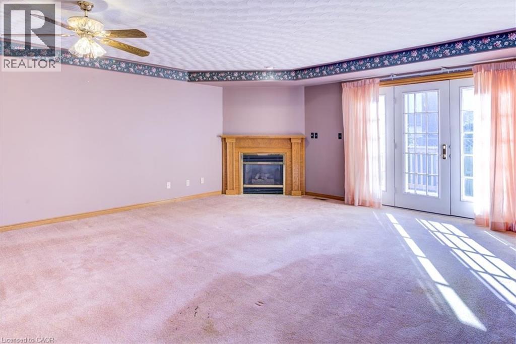 Spacious living area with a cozy gas fireplace, perfect for family gatherings, and access to your sunny deck. - 42 Donly Drive S Unit# 2, Simcoe, ON - Indoor With Fireplace