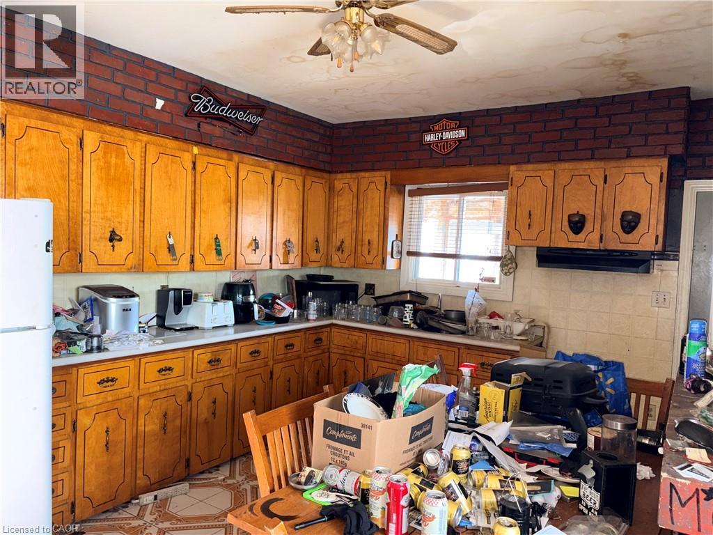 Kitchen featuring wood finish cabinetry, light countertops, freestanding refrigerator, ceiling fan, and ventilation hood - 14 Carlisle Street, Hamilton, ON - Indoor Photo Showing Kitchen