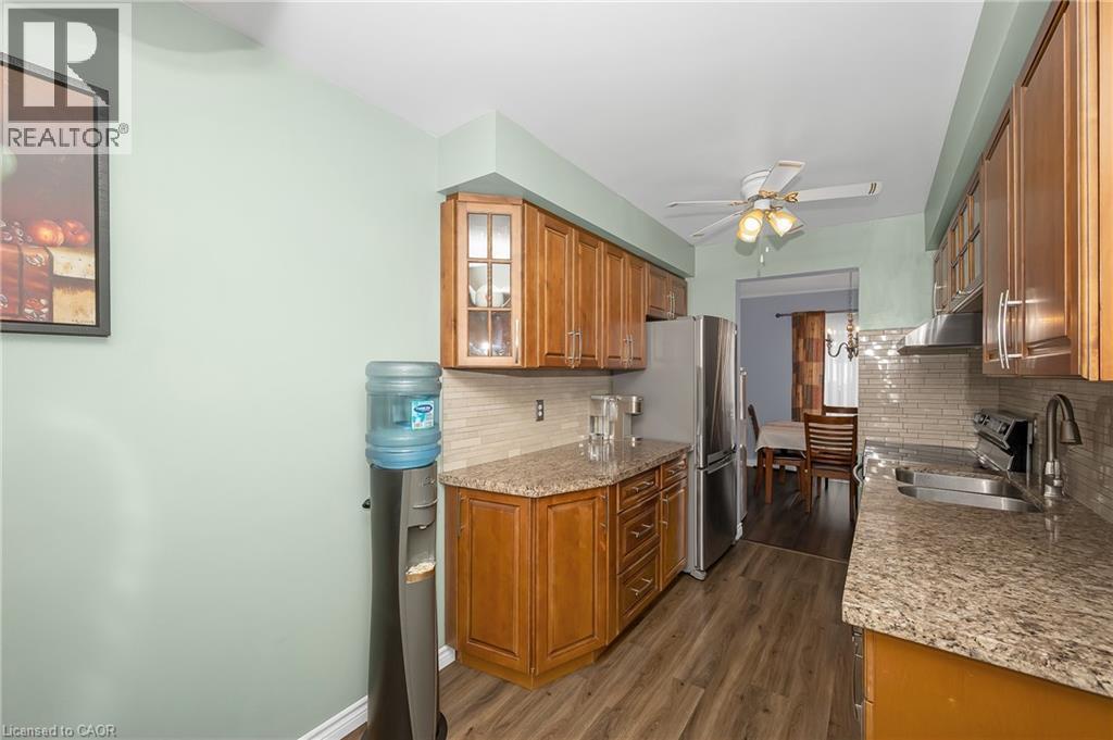 Kit.w/glass insert cabinets, wood fin.cabinetry - 375 Kingscourt Drive Unit# 21, Waterloo, ON - Indoor Photo Showing Kitchen With Double Sink