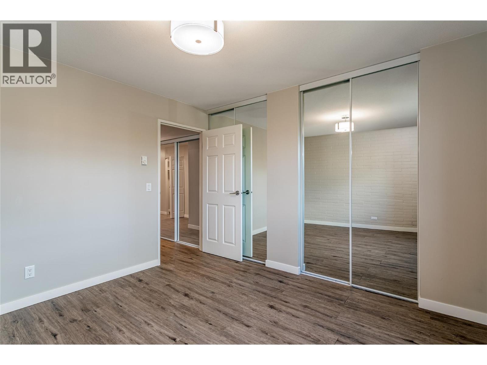 Primary bedroom with dual closets - 1915 Pacific Court Unit# 407, Kelowna, BC - Indoor Photo Showing Other Room