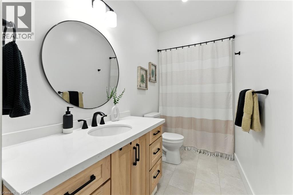 Bathroom featuring vanity, a shower with shower curtain, and light tile patterned floors - 9 Macneil Court, Port Burwell, ON - Indoor Photo Showing Bathroom